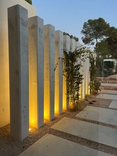 Es Rasus — colonnes illuminées, entrée de nuit